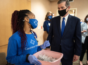 Gov. Roy Cooper talks with a health care worker.